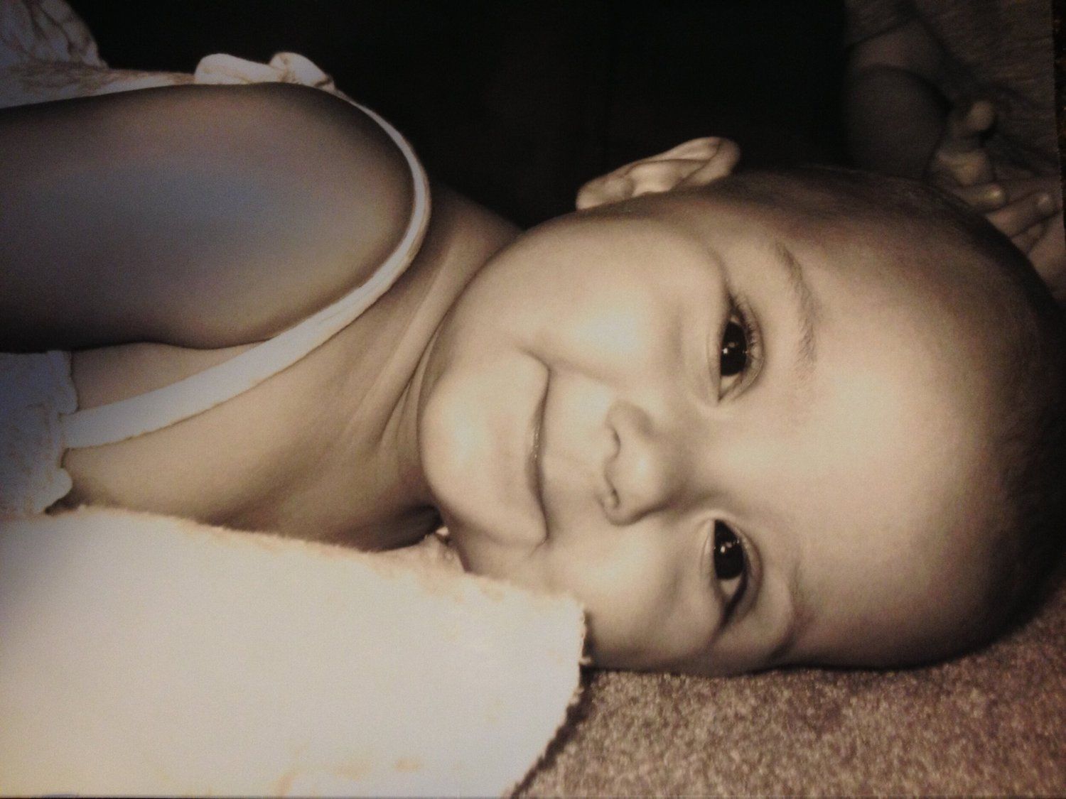 A vintage-toned photo of a smiling baby, the heart behind the bakery