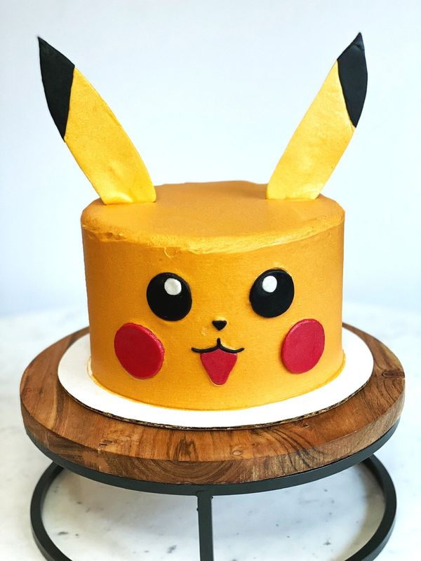 Yellow Pikachu cake with ears, rosy cheeks and a smile