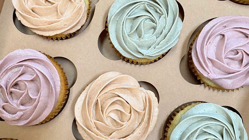 Pastel rosette cupcakes in a kraft bakery box