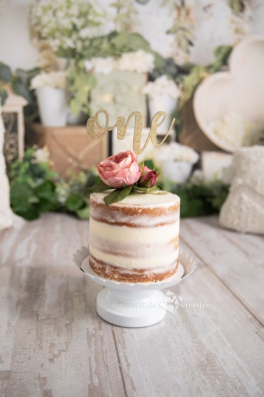 Semi-naked first birthday smash cake with a flower and &ldquo;one&rdquo; topper